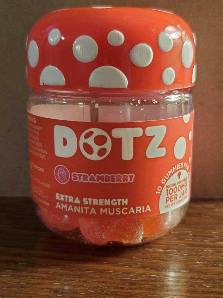 Small plastic bottle of DOTZ strawberry gummies of Amanita Muscaria mushrooms. 