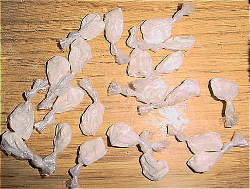 Cocaine bindles on a wood surface