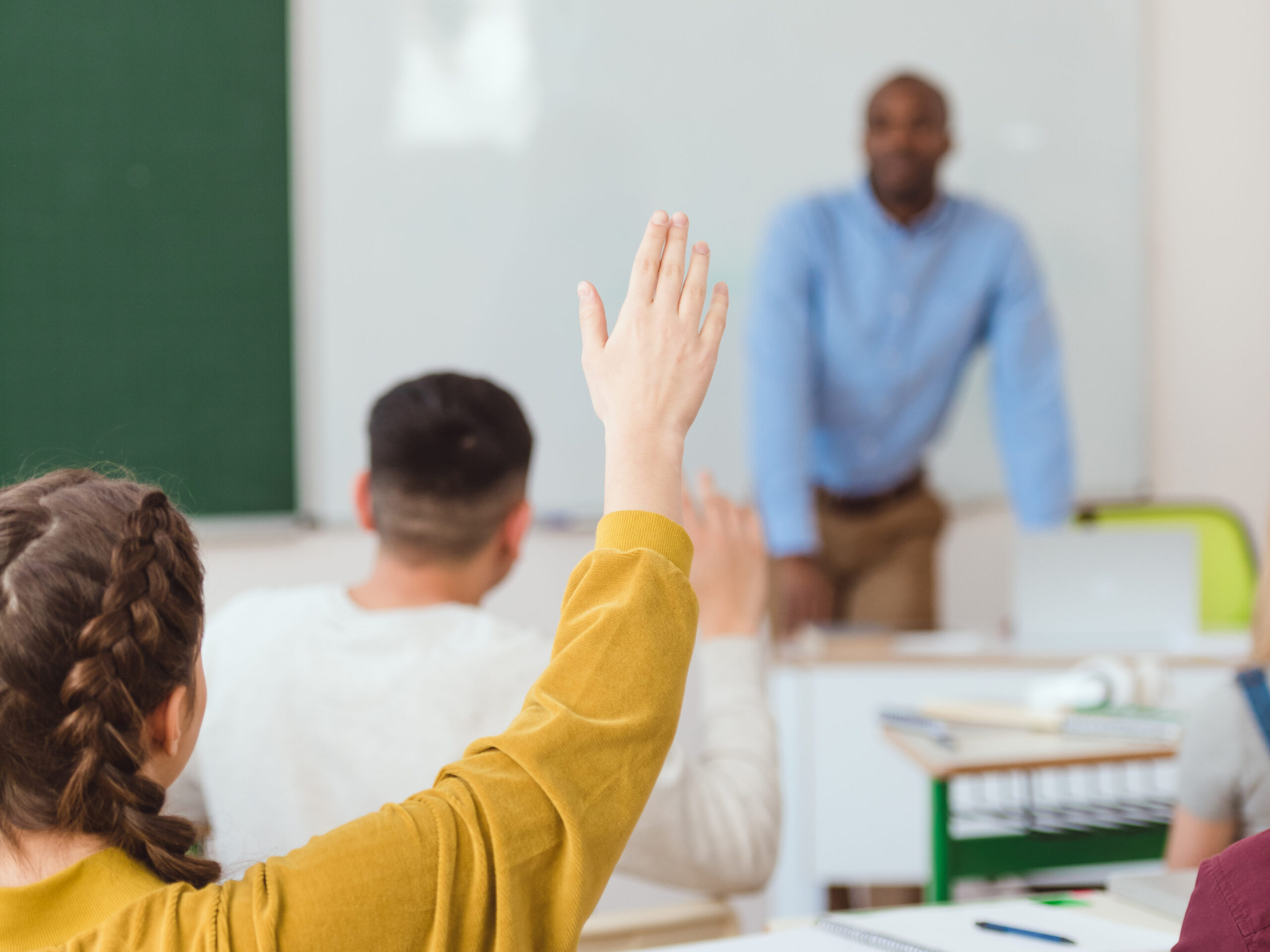 Girl raising her hand in the classroom.